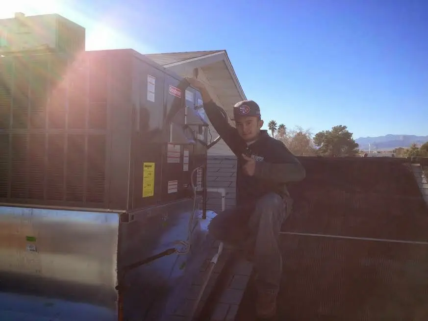 HVAC technician performing AC Tune-Up on a rooftop unit in Black Mountain